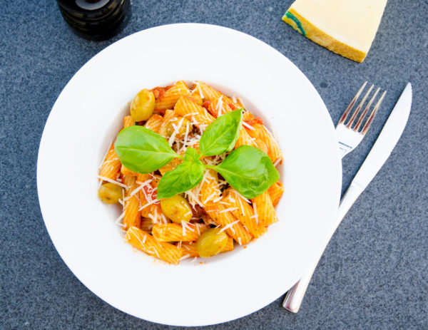 Vegetarisk pasta med oliver och zucchini i tomatsås